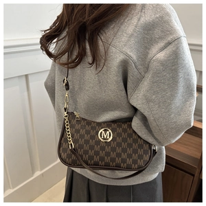Détail du sac bandoulière monogramme marron avec logo M doré et bandoulière en chaîne