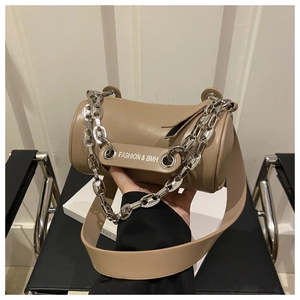 Close-up of stylish khaki cylinder crossbody bag with chunky silver chain and wide strap