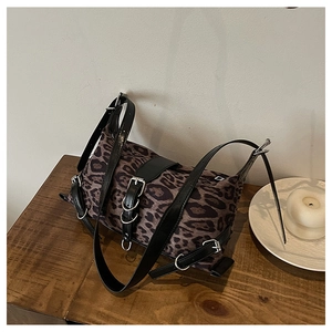 Dettaglio della borsa leopardata con cinturini in pelle nera e fibbie in metallo argento