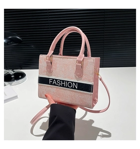 Detailed close-up of light pink crossbody bag with Fashion textured relief and top handles