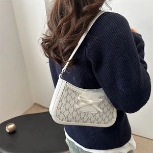 Chic cream bow shoulder bag with M-letter monogram pattern and elegant leather finish