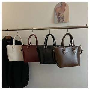 Détails de quatre sacs seaux en cuir coloré avec des ferrures métalliques de qualité