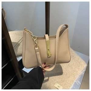 Détail d'un sac demi-lune en cuir grainé avec chaîne dorée et fermoir en métal chic