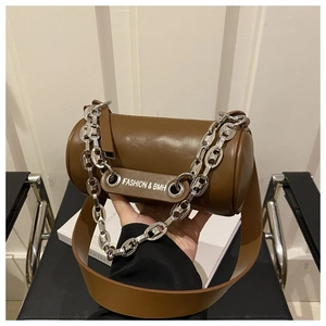 Detail of a brown cylindrical crossbody bag with silver chain and FASHION & BMH lettering