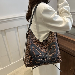 Leopard print tote bag with black butterfly lace-up detail and adjustable shoulder strap