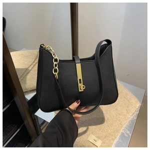 Détail du sac hobo en cuir grainé noir avec chaîne dorée et fermoir pivotant chic