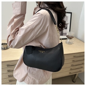 Detail of black faux leather texture with gold chain strap on a trendy underarm bag