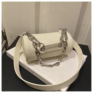 Close-up of a white cylindrical crossbody bag featuring a silver metal chain and wide strap