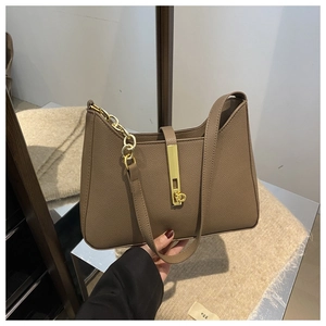Détail d'un sac à main en cuir marron foncé avec fermoir doré et chaîne élégante