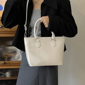 Sac seau minimaliste en cuir verni beige avec effet miroir brillant et détails dorés