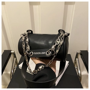 Detail of black cylindrical barrel bag with silver chunky chain and metal logo plate