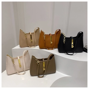 Détails de la texture du cuir grainé et des ferrures dorées sur les sacs en croissant