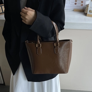 Sac seau en cuir gras marron avec poignées épaisses et design rétro minimaliste