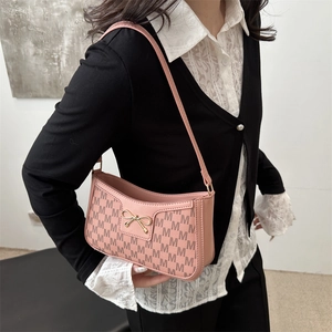 Pink crescent underarm bag with monogram print and golden bow buckle on model