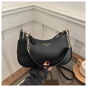 Close-up of black lychee grain leather crescent bag with golden chain and branding