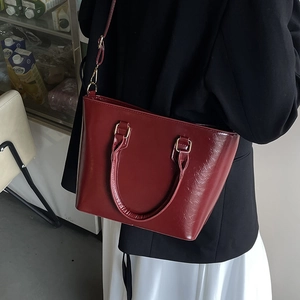 Sac seau bordeaux en cuir verni brillant avec poignée et bandoulière amovible
