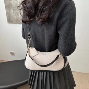 Chic beige lychee leather crescent bag with black piping and gold chain strap for women