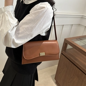French style caramel rectangular underarm bag with vintage gold buckle on model