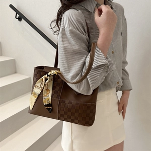 Brown leather tote bag with woven checkerboard pattern and floral silk scarf accessory