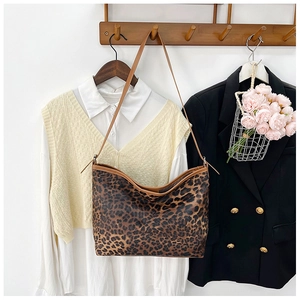 Borsa tote leopardata abbinata a camicia bianca e gilet in maglia beige per outfit casual
