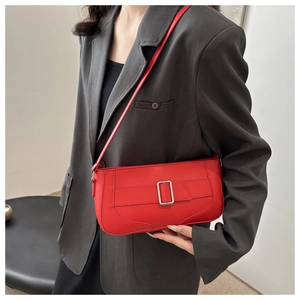 Detail of red leather underarm bag featuring a stylish silver buckle and adjustable strap