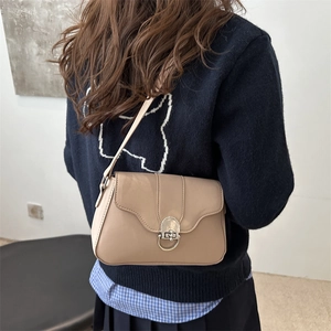 Borsa a spalla minimalista in pelle beige con patta ondulata e fibbia ad anello argento