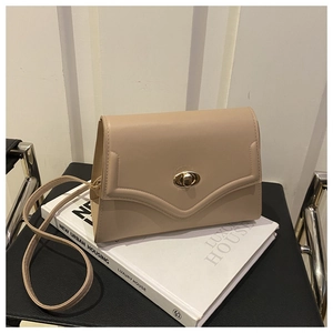 Dettaglio della borsa in pelle beige con patta a onda e chiusura a girello dorata
