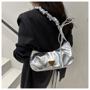 Detail view of silver pleated croissant bag with golden triangle metal buckle decoration
