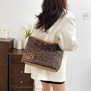 Grande borsa shopper leopardata con rifiniture in pelle marrone in un interno curato