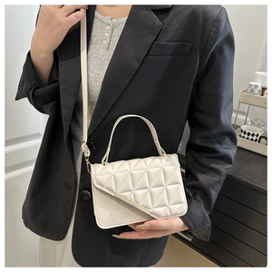 Close-up of cream white quilted bag with geometric stitching and gold hardware detail