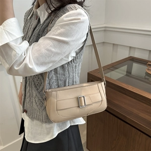 Minimalist beige crescent underarm bag with metal buckle on leather strap shoulder strap