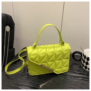 Detail of neon green small handbag with 3D geometric quilted pattern and metal hardware