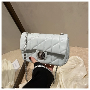 Detail showing mint blue quilted crossbody bag with silver twist lock and chain strap