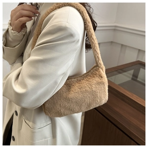 Detailed texture of brown faux fur shoulder bag worn with a chic cream-colored blazer