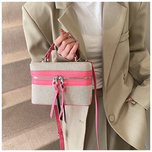 Detail showing the pink leather trim and canvas texture of this trendy crossbody bag
