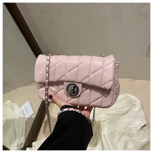 Detailed shot of light pink quilted shoulder bag with silver chain and metal clasp
