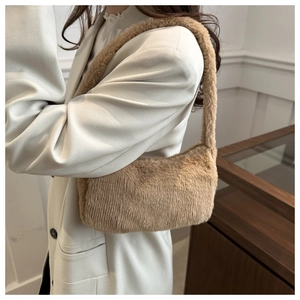 Close-up of plush faux fur underarm bag in beige showing soft texture and design