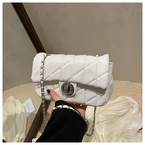 Detail of white quilted crossbody bag with silver twist lock and woven chain strap