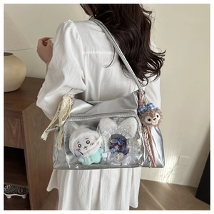 Detail view of silver ita bag with clear window showing cute anime plushies and lace decor