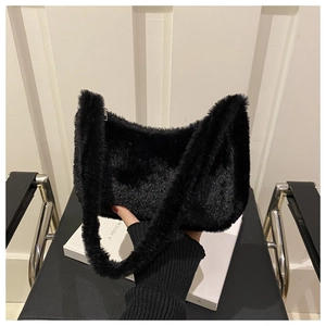 Detail of black faux fur underarm bag with soft texture on a modern minimalist chair