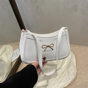 Sac sous le bras minimaliste en cuir blanc avec nœud doré et bandoulière élégante
