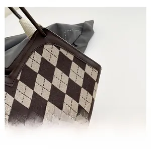 Close-up of argyle patterned tote bag featuring premium leather trim and precise stitching