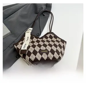 Detail of quilted tote bag with brown and beige woven texture and leather trim