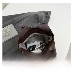 Internal view of dark brown tote bag showing large capacity for tablet and cosmetics