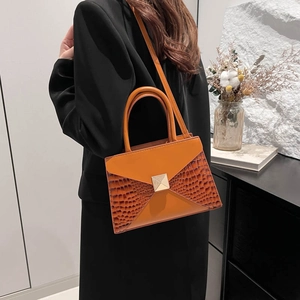 Structured orange and brown crocodile pattern crossbody bag with golden pyramid lock clasp