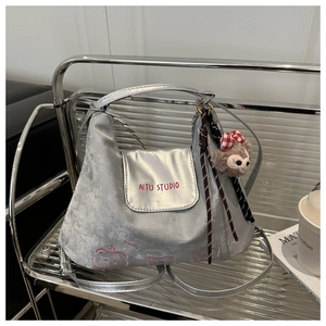 Silberne Samt-Hobo-Tasche mit pinker Stickerei und einem süßen Plüschtier-Anhänger