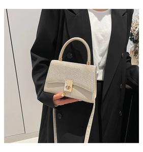 Dettaglio dell'elegante borsa quadrata crema con paillettes oro champagne e chiusura a scatto