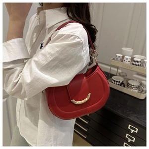 Detail view of red crescent hobo bag featuring premium leather and gold hardware buckle