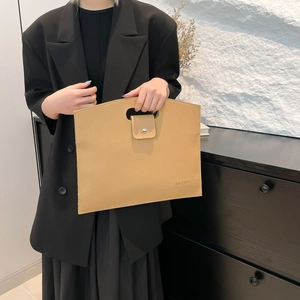 Minimalist beige textured leather tote bag with cutout handles for professional women