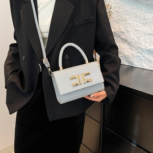 Schicke silberne Pailletten-Tasche mit goldener H-Schnalle an einem Model